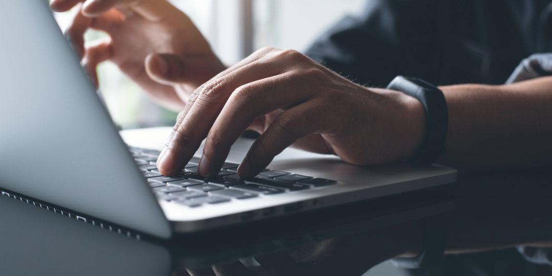 Unas manos tecleando con un ordenador portátil 
