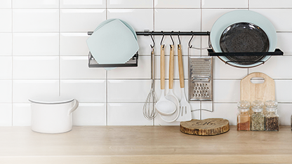 Utensilios de cocina y vajilla ordenados sobre la encimera de la cocina.