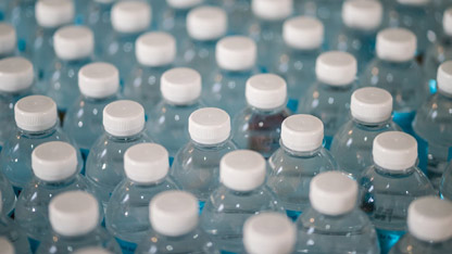 Filas de botellas de agua de plástico y materiales plásticos en contacto con alimentos.